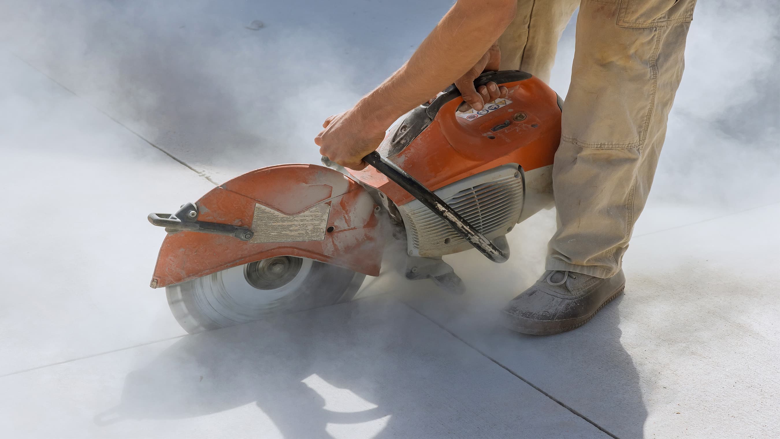 Man using electric tool to cut into stonework