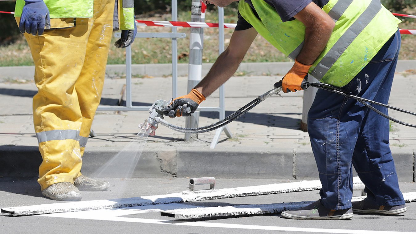 Man painting lines on parking lot